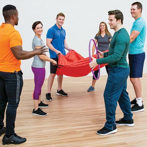 SPARK trainer smiles with a football in hand.